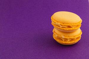 Yellow macarons on a purple background in a sweet display photo