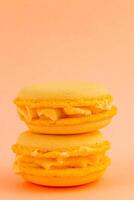 Bright yellow macarons stacked on a pastel background photo