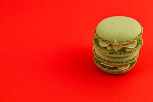 Delightful green macarons stacked on vibrant red backdrop photo