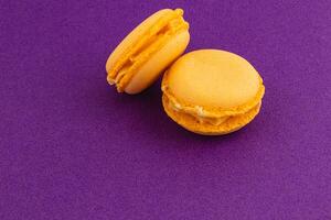 Yellow macarons on a vibrant purple background photo
