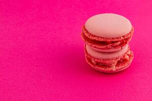 Delicious pink macarons stacked on a vibrant background photo