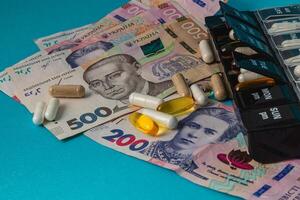Money and medicine displayed together on colorful surface photo