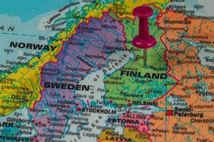 Finland marked on a map with a pushpin in focus photo