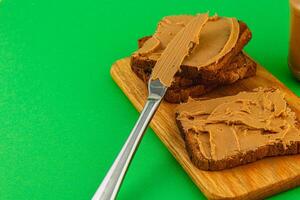 Creamy peanut butter spread on whole grain bread slices photo