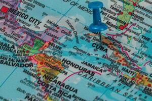 Location marker highlights Cuba on a colorful world map photo