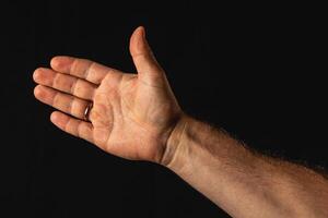 Hand gesture expressing openness on a dark background photo
