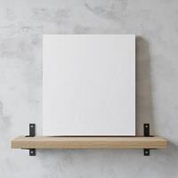 blank white canvas hanging on a wooden shelf against a gray concrete wall. The canvas is rectangular in shape and appears to be made of a light-colored wood. photo