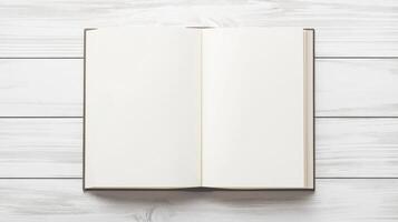 open plain white book or magazine lying on a white wooden surface. The book appears to be blank, with no text or images on the pages photo