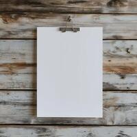 blank white paper hanging on a wooden wall. The paper is hanging from a metal hook on the wall photo