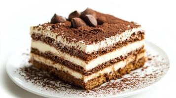 Delicious layers of creamy dessert topped with chocolate on a white plate photo