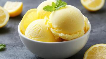 Delicious lemon sorbet served in a bowl with fresh lemon slices and mint garnish photo