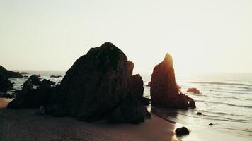 Sharp peaks of rocks on the seashore washed by sea waves. Drone at sunset - sunset photo