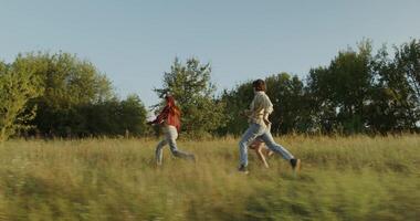 Three young friends are having fun and running around the field on a sunny day. photo