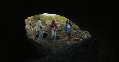 Friends are standing near the ruins. They are talking while looking at the destroyed building. View from the building basement photo