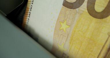 Euro banknotes in the counting machine. The currency of the European Union. Close-up photo