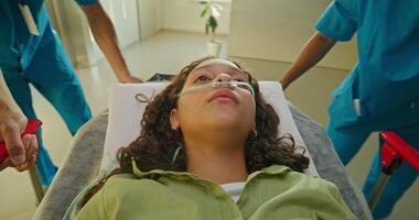 Medics are taking a woman on a gurney along the hospital corridor. The oxygen tube photo