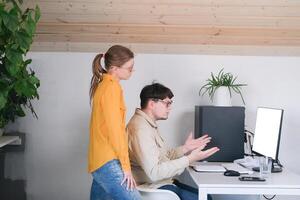 millennial man and woman in casual clothes using and computer while spending time at home photo