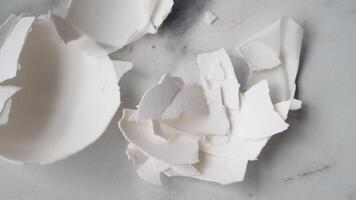 Eggshell fragments scattered on a countertop surface video
