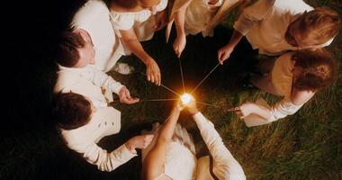Top view of the guests lighting sparklers and start dancing with them around the bride and groom, wedding concept photo