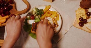 Woman's hands use cutlery cutting steak with vegetables. A woman is sitting at a festive table, a close-up of her hands photo