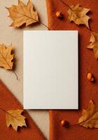 Blank white card on orange background with autumn leaves and berries photo