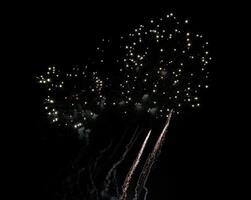 Stunning fireworks display against a dark night sky. Bright bursts of light and sparkling trails create a dynamic and celebratory scene. photo