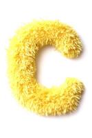 Soft and fluffy yellow letter C is displayed on a white background, showcasing its bright color and fun texture ideal for kids' decor or toys photo