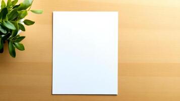 Close-up of a blank white sheet placed on a natural wood desk alongside a small green plant, conveying simplicity and potential for creativity photo
