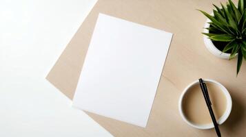 Blank white sheet rests on a wooden desk, accompanied by a coffee cup and a small green plant, creating a calm workspace atmosphere photo
