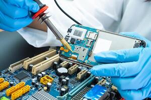technician repairing inside of hard disk by soldering iron. Integrated Circuit. the concept of data, hardware, technician photo