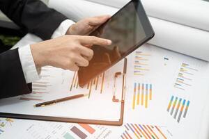 accountant working and analyzing financial reports project accounting with chart graph and calculator in modern office, finance photo