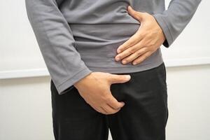 Hernia, Asian man stomach ache, abdominal pain and urology problem health. photo