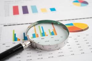 Magnifying glass on spreadsheet graph paper. photo