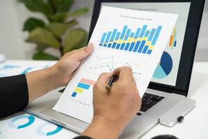 accountant working and analyzing financial reports project accounting with chart graph and calculator in modern office, finance and business concept. photo