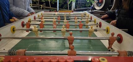 table football pitch, or foosball table, during a game between friends with the table football men chasing the ball photo
