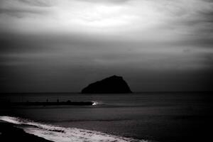 calm background of bergeggi island in black and white with silky sea water photo