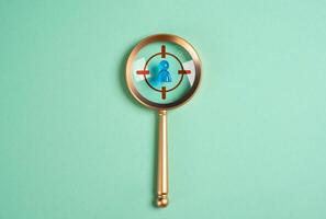 Magnifying glass and a human figure under the gun. Concept of searching and recruiting workers. Acquiring talent. Selecting top professionals under urgency. Seek ideal candidates photo