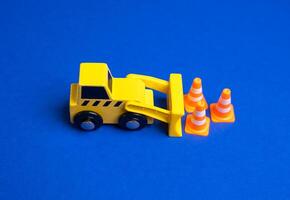 A yellow bulldozer moves traffic cones. The concept of establishing or removing restrictions. Implementing new rules. Construction zones. Policy adjustments, and public safety measures. photo