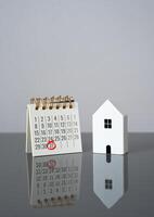House and calendar with date marked. Last day of rent payment, tenants moving out. Deadline for property taxes. Complete rent payments, finalize leases, or pay property-related taxes. Housing cycle photo