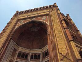 Buland Darwaza, the grand entrance to Fatehpur Sikri, a historical city near Agra built by Emperor Akbar.A towering red sandstone gateway with intricate Mughal architecture and inscriptions. photo