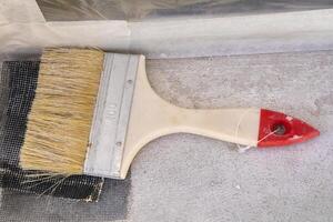 Flat paint brush number 100 with red handle ending for house renovation. photo