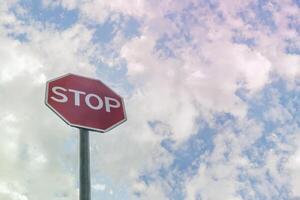 Road sign STOP with light cloudy sky in background. photo