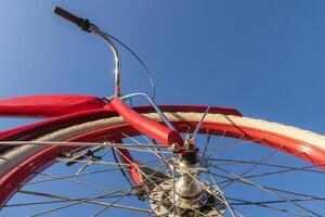 Close up of red bicycle front wheel. Low angle view. photo