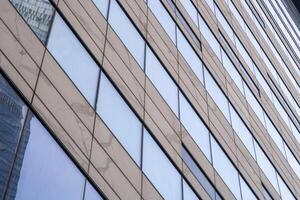 Modern building wall with another building and sky reflection. Business background. photo