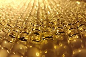 Golden bubbles shimmer under warm light, creating a mesmerizing abstract pattern. photo