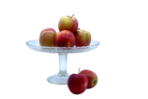 Group of fresh red apples on an elegant glass cake stand with two apples beside it, isolated, no background. Ideal for healthy food concepts and minimalist designs. png