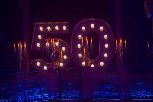 The dark background of the stage with candelabra and the number fifty. photo