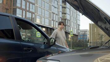 The driver of an inexpensive car, who was shocked by a collision with an expensive car, is horrified. He puts his head in his hands, imagining how much the repairs will cost. video