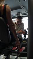 Beginner trainer is counting number of times athlete performs leg exercises in gym. He ensures that athlete follows correct technique to achieve best possible results. video