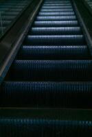 Escalator in a modern shopping center in dark tones photo